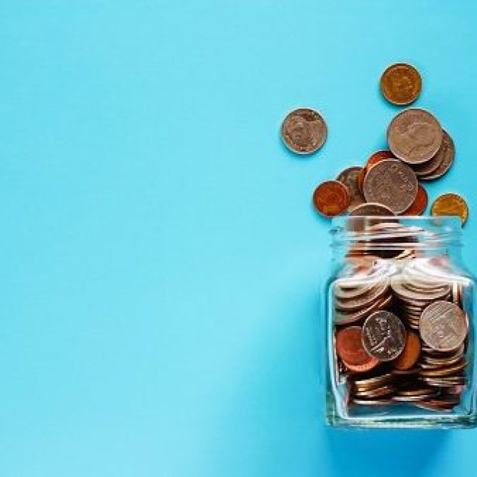 Coins in glass jar and outside, Thai currency money on blue background for business and finance concept