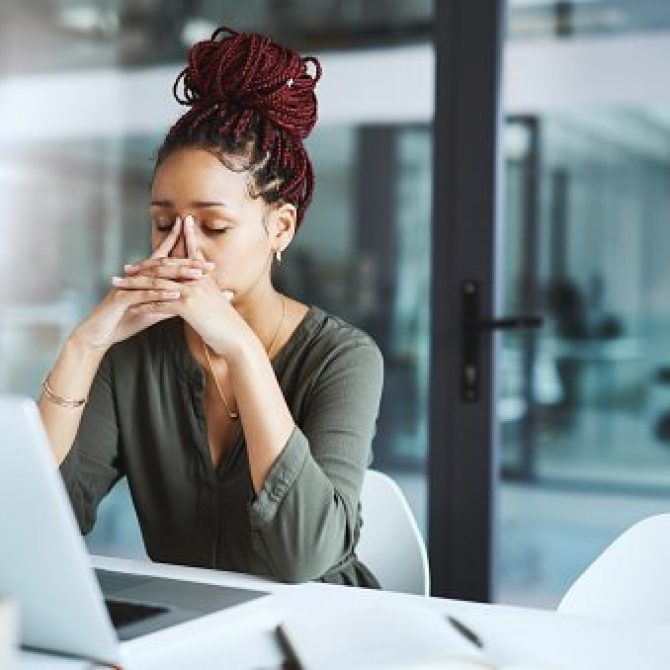 Shot of a young businesswoman looking stressed out while working in an office